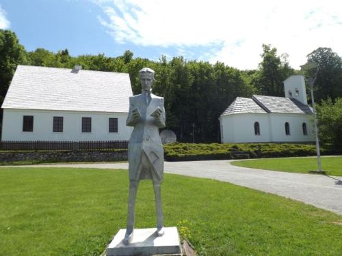 a statue of a man standing in the grass at Villa Zora - Oaza mira u srcu Like in Gornja Ploča