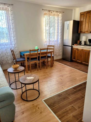 a kitchen and dining room with a table and a refrigerator at Villa Zora - Oaza mira u srcu Like in Gornja Ploča
