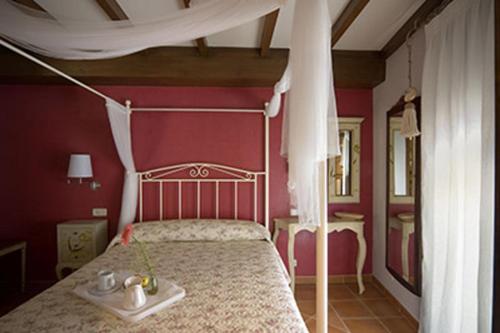 ハライス・デ・ラ・ベラにあるApartamentos Rurales Cumbres de Gredosのベッドルーム1室(白い天蓋付きのベッド1台付)
