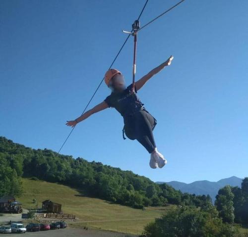 a person is hanging on a zip line at Villa Zora - Oaza mira u srcu Like in Gornja Ploča