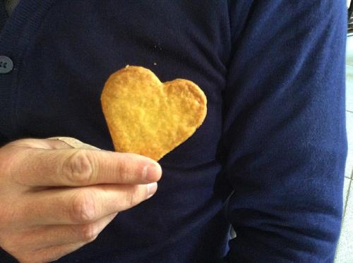 a man is holding a heart shaped doughnut at Hotel La Torre in Castiglione dʼIntelvi