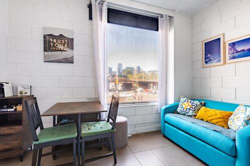 a living room with a blue couch and a table and a window at Prime Location - Newly renovated Quaint 1BR Apt! in Melbourne