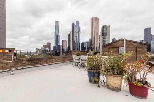 a rooftop with tables and chairs and a city skyline at Prime Location - Newly renovated Quaint 1BR Apt! in Melbourne