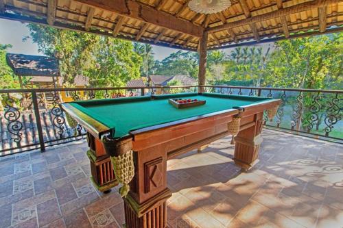 a pool table on top of a balcony at POUSADA DAS ORQUIDEAS20 in Guapimirim