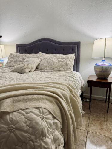 een slaapkamer met een bed en een tafel met een lamp bij Cozy Room close to the strip in Las Vegas in Las Vegas