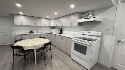 a kitchen with white appliances and a table and chairs at Spacious stay, 15 min to Niagara Falls & US border in Thorold