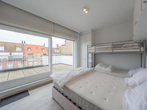 a bedroom with a bed and a large window at Stylish City-View Retreat in Knokke-Heist