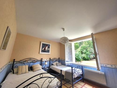 une chambre avec deux lits et une fenêtre dans l'établissement Maison Brévinoise proche de la plage - 5 personnes - FR-1-364-81, à Saint-Brévin-les-Pins