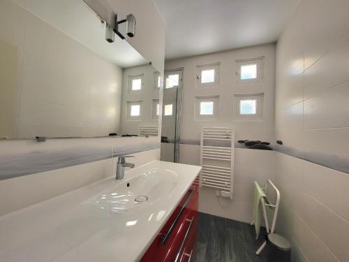 une salle de bain avec un lavabo blanc et un miroir dans l'établissement Maison Brévinoise proche de la plage - 5 personnes - FR-1-364-81, à Saint-Brévin-les-Pins