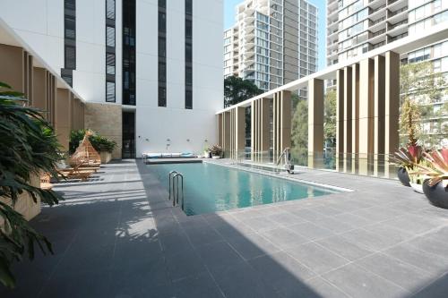 una piscina in un edificio con edifici alti di MQ Lux 2BR Apartment with study, pool, free parking, Metro a Sydney