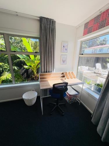 an office with a desk and a chair and a window at Papamoa Family Beach House in Tauranga