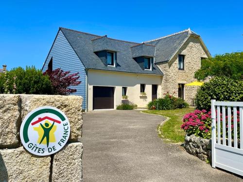 une maison avec un panneau en face d'une allée dans l'établissement Villa Kérity-Ki - au coeur du port typique de Kérity, à Penmarcʼh