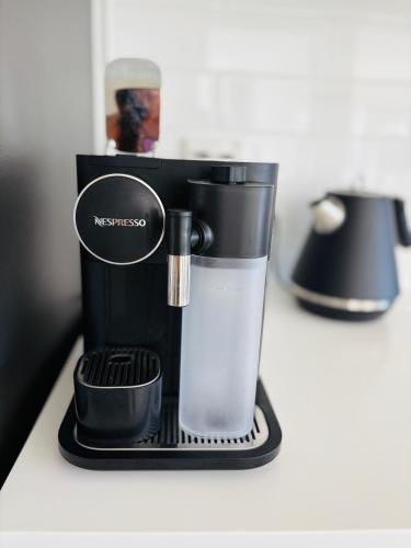 a black coffee maker sitting on top of a counter at Papamoa Family Beach House in Tauranga