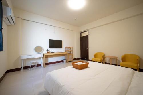 a bedroom with a bed and a desk and chairs at 夏米旅宿 in Lugang