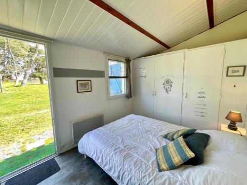 une chambre avec un lit et une grande fenêtre dans l'établissement Maison T3 à 800 m de la plage avec piscine chauffée, tennis, Wi-Fi, patio clos et parking privatif - FR-1-231-300, à Bretignolles-sur-Mer