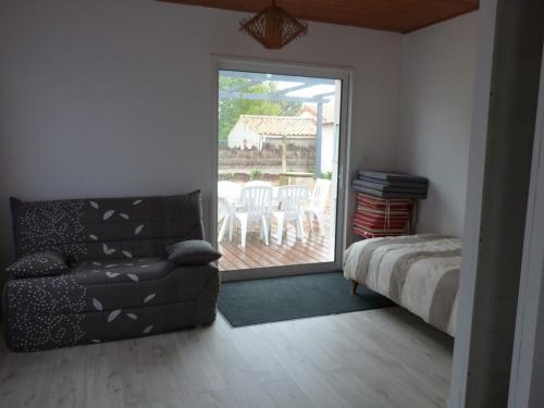 un salon avec un canapé et une porte coulissante en verre dans l'établissement Maison rénovée avec jardin, près de la plage, parking, pour 4-6 personnes - FR-1-194-96, à La Tranche-sur-Mer