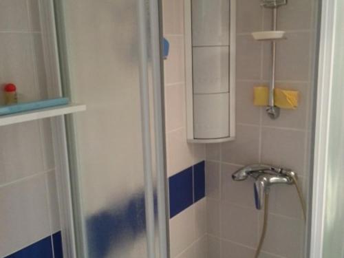 une salle de bain avec une douche avec pommeau de douche dans l'établissement Charmante maisonnette avec piscine commune proche plage - FR-1-194-84, à La Faute-sur-Mer