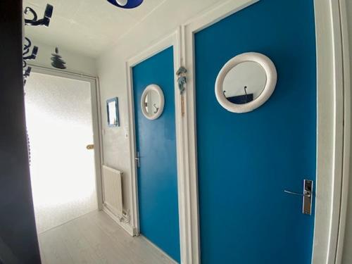 un couloir bleu avec un miroir et une porte bleue dans l'établissement Studio agréable avec balcon et vue mer aux Sables-d'Olonne - FR-1-92-623, à Les Sables-dʼOlonne