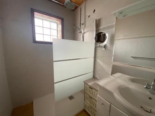 une salle de bain blanche avec un lavabo et une fenêtre dans l'établissement Maison à deux pas de la plage avec jardin privatif et tout confort - La Tranche-sur-Mer - FR-1-22-218, à La Tranche-sur-Mer