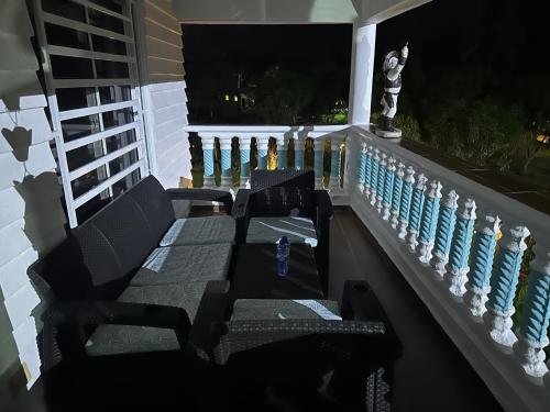 a porch with two chairs and a railing at night at villas ecologicas hacienda vista linda in Cabrera