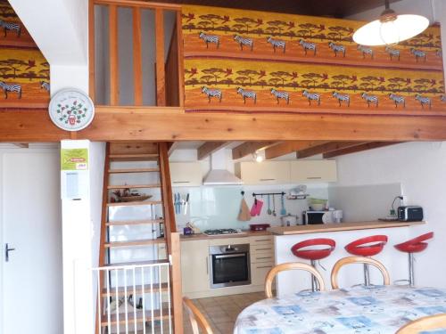 un lit en mezzanine dans une cuisine avec une table et des chaises dans l'établissement Maison paisible à La Terrière proche plage et commerces - FR-1-194-209, à La Tranche-sur-Mer