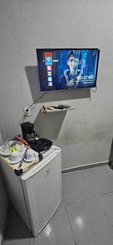 a flat screen tv on a wall with a table at Só pra relaxar! in Manaus