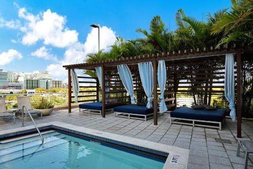 a swimming pool with chairs and a gazebo at Exclusive unit in Miami Sunshine in Miami