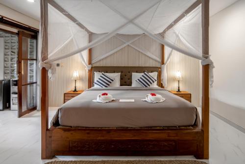a bedroom with a bed with two swans on it at PNB Bali Villas in Canggu