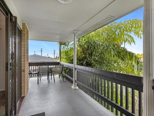 a balcony with a table and chairs on it at Spacious 3-Bed Home with Large Balcony in Hervey Bay