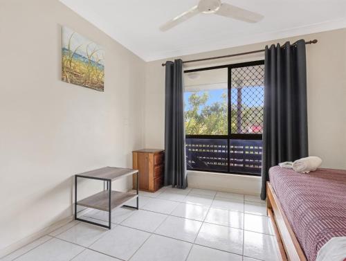 a bedroom with a bed and a window at Spacious 3-Bed Home with Large Balcony in Hervey Bay