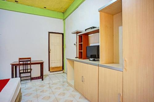 a room with a kitchen and a bed and a table at Hotel O Triarga in Takengon