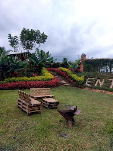 El PeñolにあるEntre Colinas Lodgeのベンチ2台とピクニックテーブル付きの公園