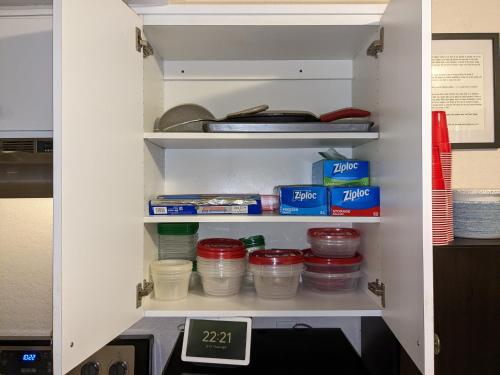 an open pantry with food items and a clock at Introverts Paradise! Central Largo and Pinellas! 15 mins to beaches! in Largo