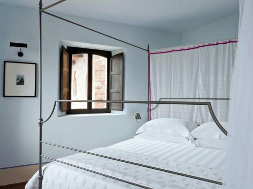 1 dormitorio con cama con dosel y ventana en Heritage Holiday Home in Gabiano with Swimming Pool, en Gabiano