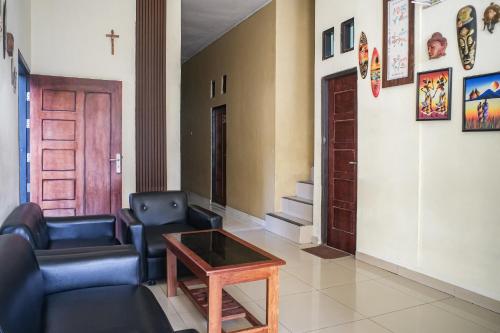 a living room with a couch and a table at OYO 93332 Kharis Home Stay in Jayapura