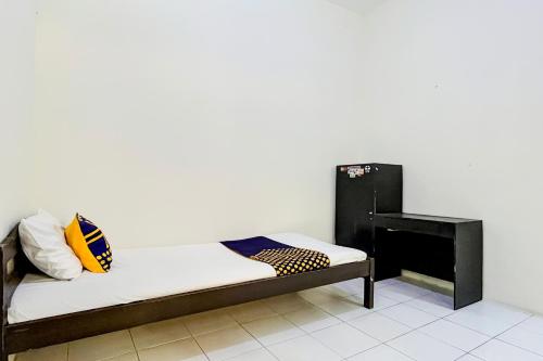 a bed in a room with a fireplace at OYO Life 93398 Sudimoro Guest House Syariah in Blimbing