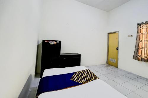 a small room with a bed and a door at OYO Life 93398 Sudimoro Guest House Syariah in Blimbing
