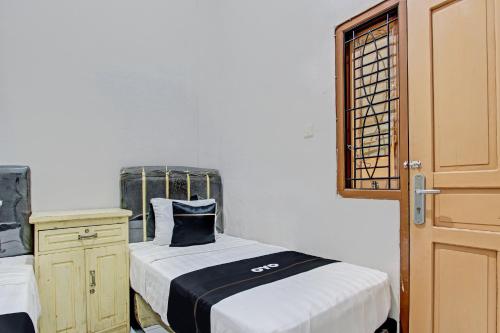 a small bedroom with a bed and a window at Capital O 93361 Dynasty Inn Syariah in Pekalongan