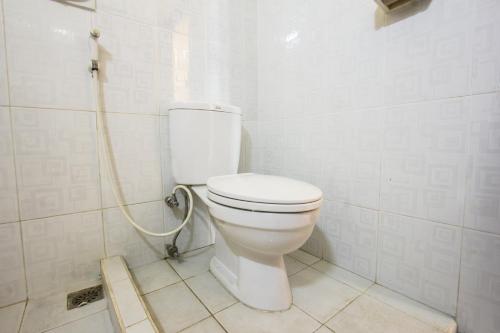 a bathroom with a toilet with a hose at Capital O 93391 Golden Manggis Hotel Near SMKN 1 Lingsar in Narmada