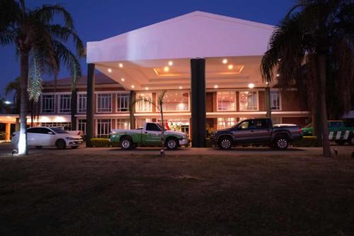 two trucks parked in front of a building at night at CATANGE HOTEL in Charata