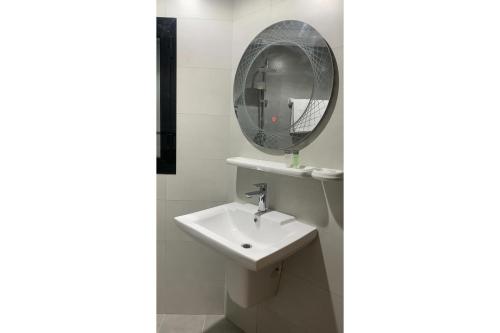 a bathroom with a sink and a mirror at OYO Townhouse 156 Rose Hotel Apartments in Muscat