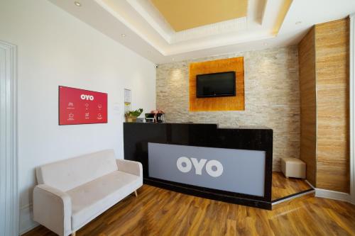 a living room with a tv and a white couch at OYO Eagle House Hotel, St Leonards Hastings in St. Leonards
