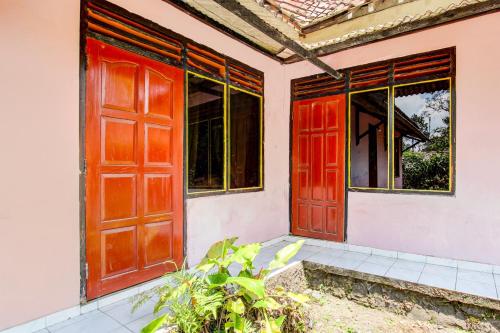 an entrance to a house with red doors at Hotel O Pondok Wisata Sekar KemuningNearWonogondang Camp ( Bumi Perkemahan Wonogondang ) in Yogyakarta