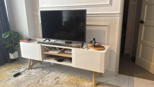 una televisione su un mobile bianco in soggiorno di Casa Leia at Troika Kota Bharu a Kota Bharu
