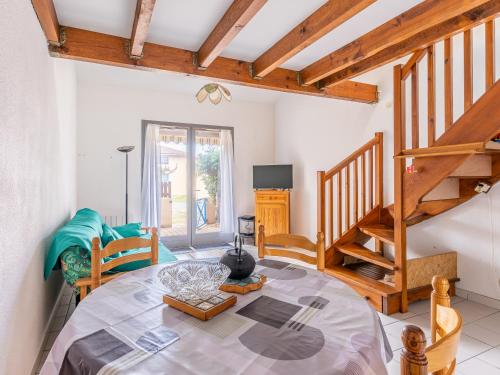 salon ze stołem i schodami w obiekcie Maison T2 avec Mezzanine, Terrasse et Parking à 300m de la Plage - Biscarrosse - FR-1-521-214 w mieście Biscarrosse