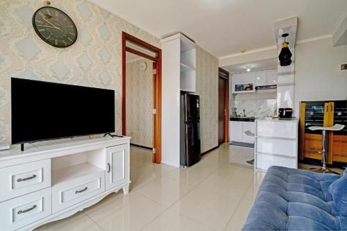 a living room with a flat screen tv on a wall at OYO Life 93097 Apartemen Gateway Pasteur By Kaisar Room in Bandung
