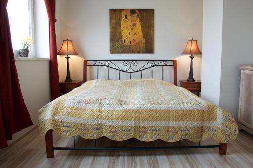 プラハにあるApartments Cordeusのベッドルーム1室(ベッド1台、ランプ2つ、絵画付)
