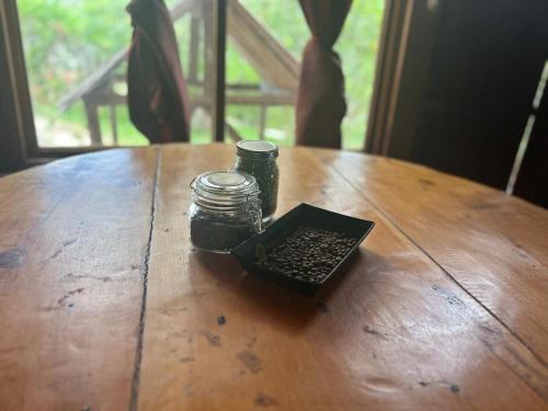 a table with two glass jars and a box of seeds at La Cabaña de Tuto Estate Coffees in San Pablo
