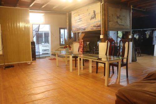 a dining room with a glass table and chairs at Atash Eco Village Homestay Van Hoi in Quân Khê