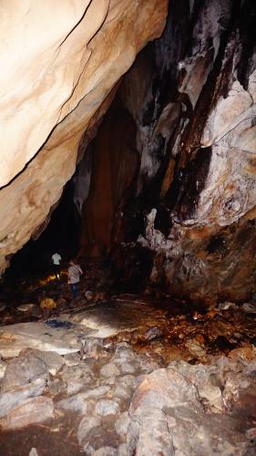 a person standing in a cave with an umbrella at Atash Eco Village Homestay Van Hoi in Quân Khê